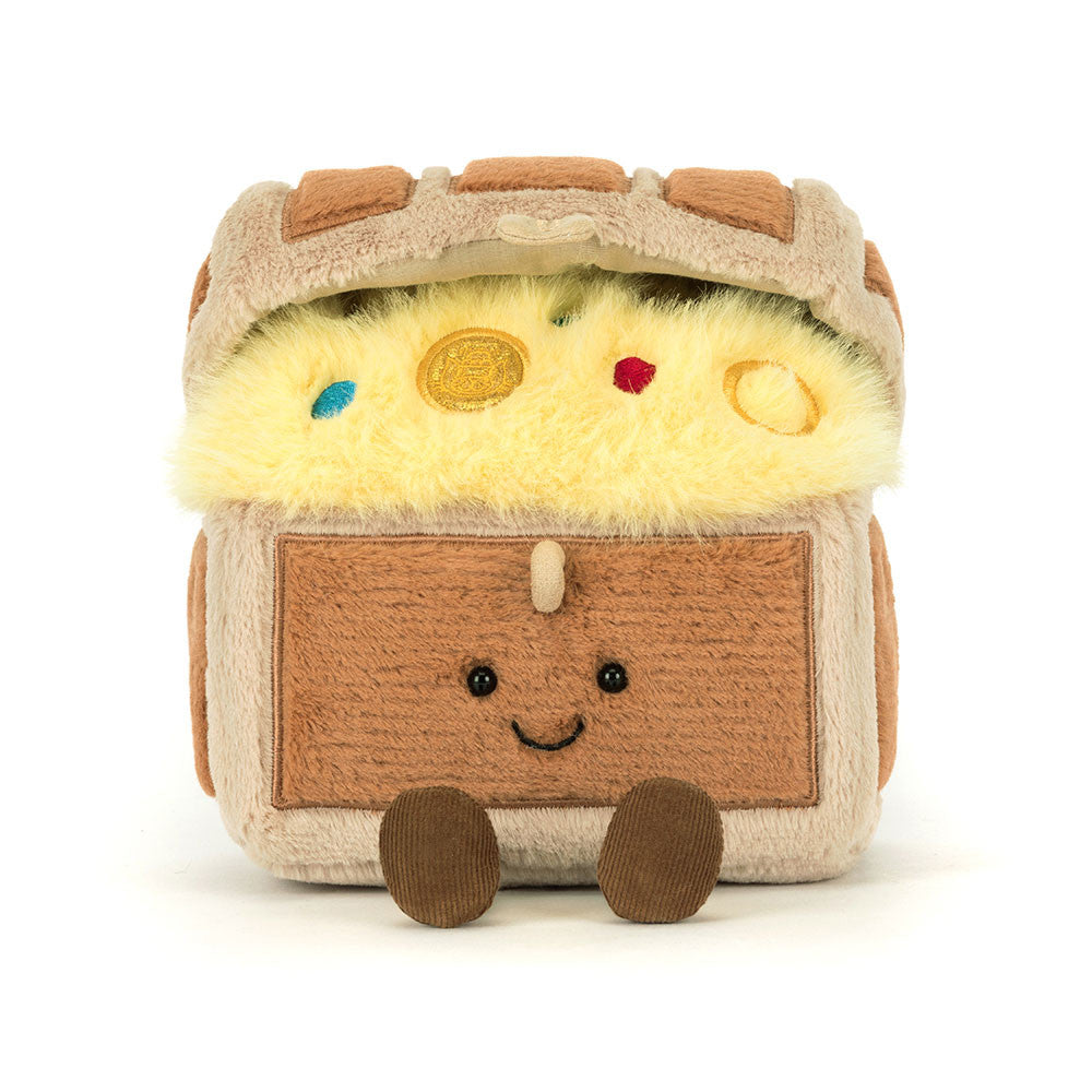A plush toy shaped like a treasure chest with a smiling face, featuring yellow faux fur inside, brown and beige fabric textures, and small colorful gem accents on a plain white background.