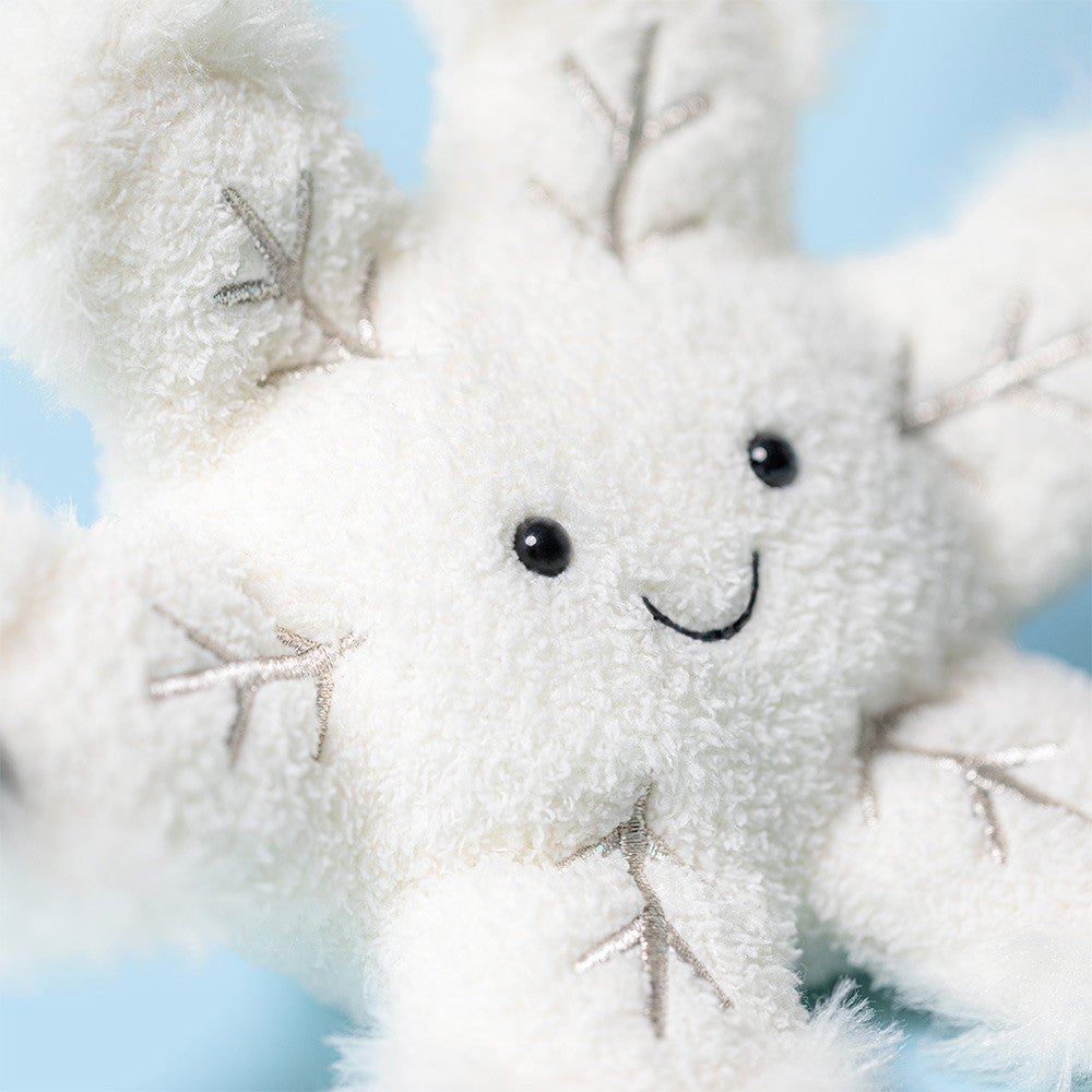 White plush toy with a smiling face against a light blue background