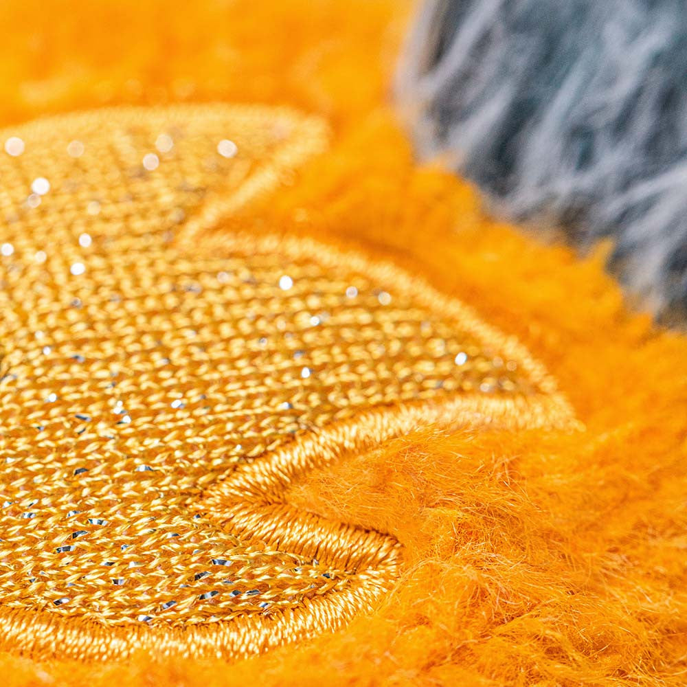 Close-up of orange fabric with textured pattern and sequins.