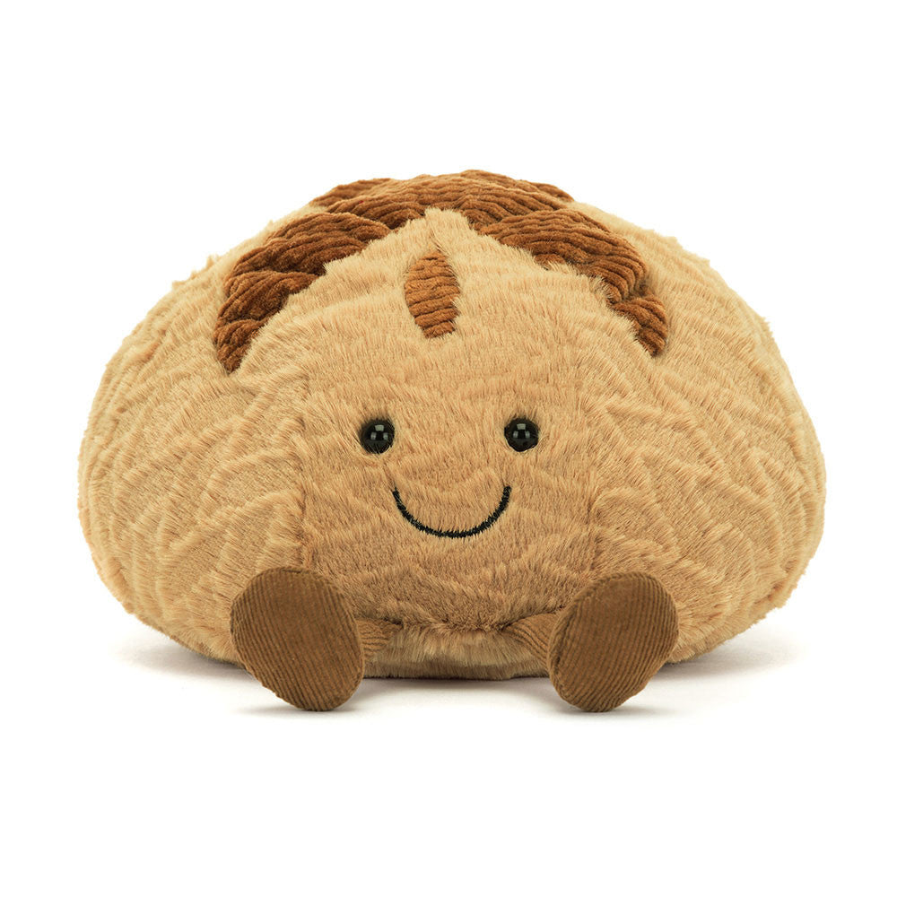 Plush toy resembling a loaf of bread with a smiling face on a white background