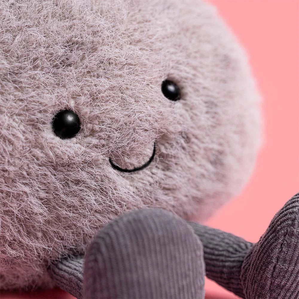 Plush toy with a smiling face on a pink background