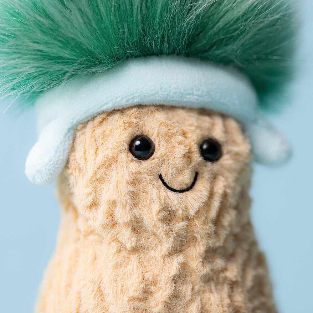 Plush toy with a green mohawk and blue headband on a light blue background