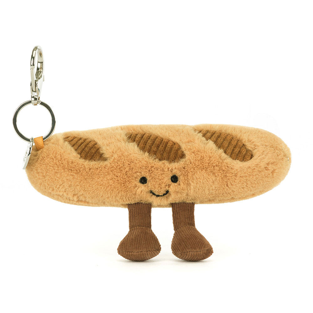 Plush baguette keychain with a smiling face on a white background