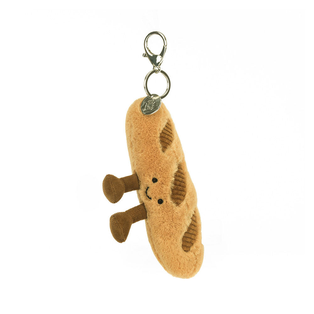 Plush baguette-shaped keychain with a smiley face on a white background
