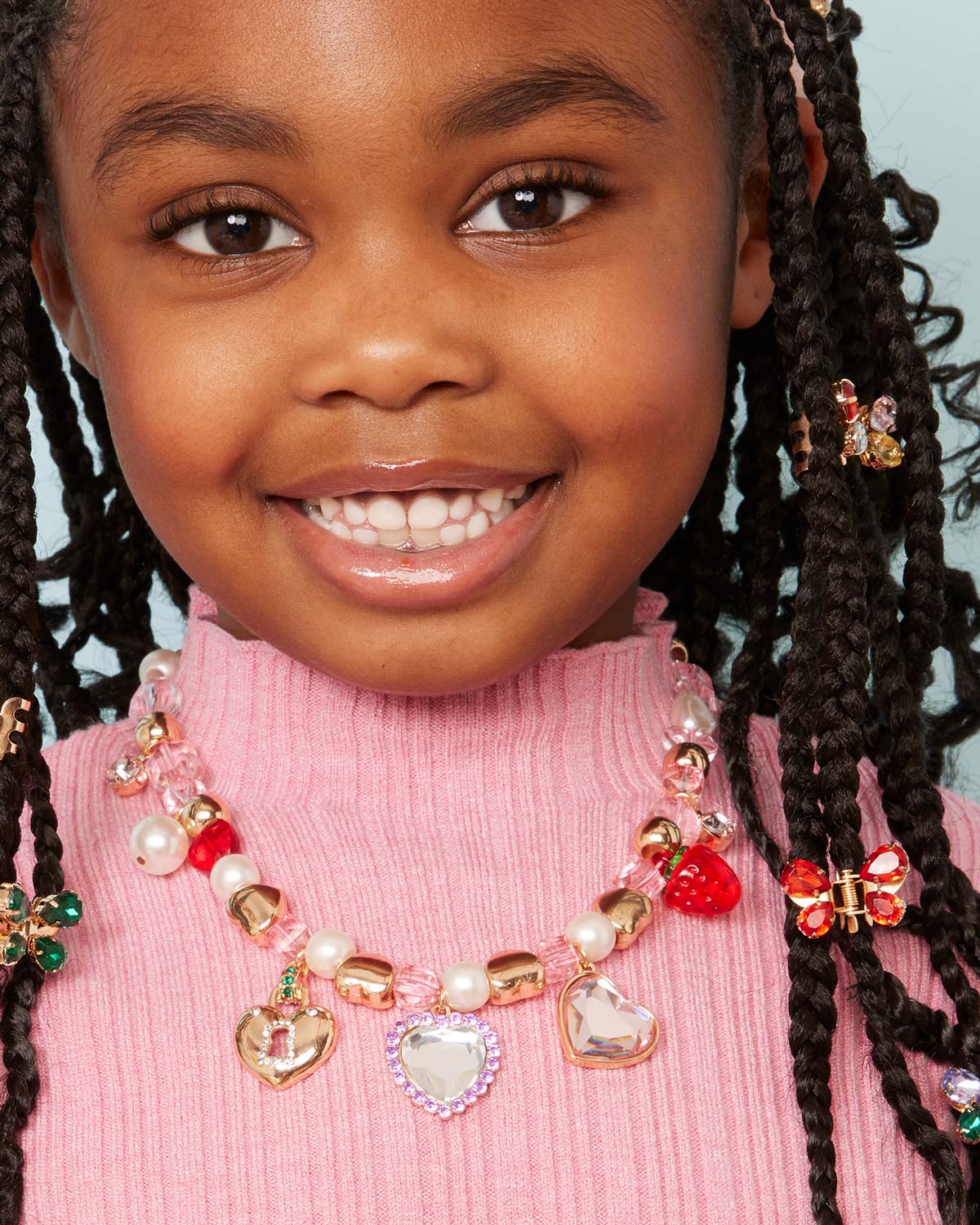 Close-up of a child wearing a colorful necklace with heart-shaped charms.