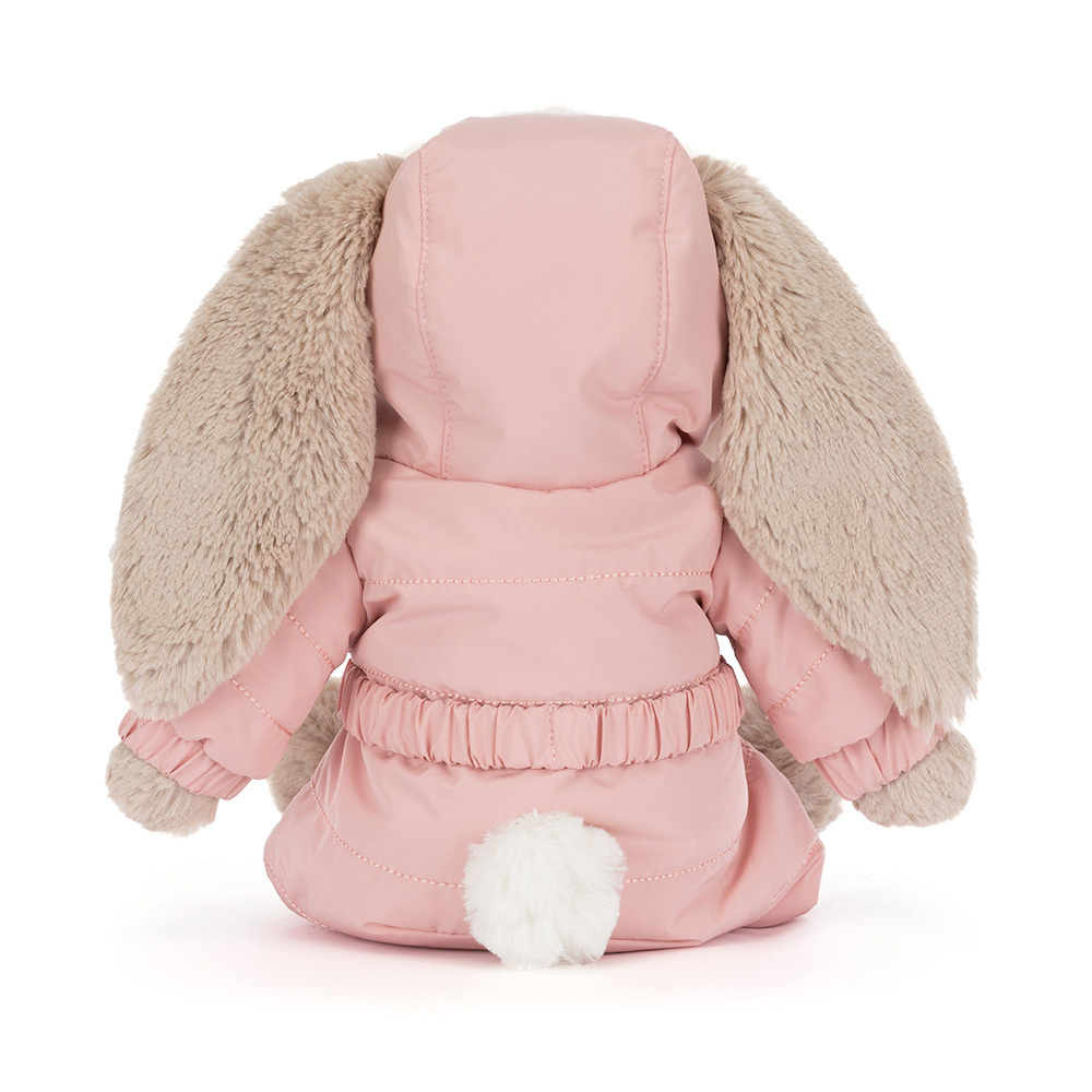 Plush toy dog in a pink outfit with fluffy ears on a white background
