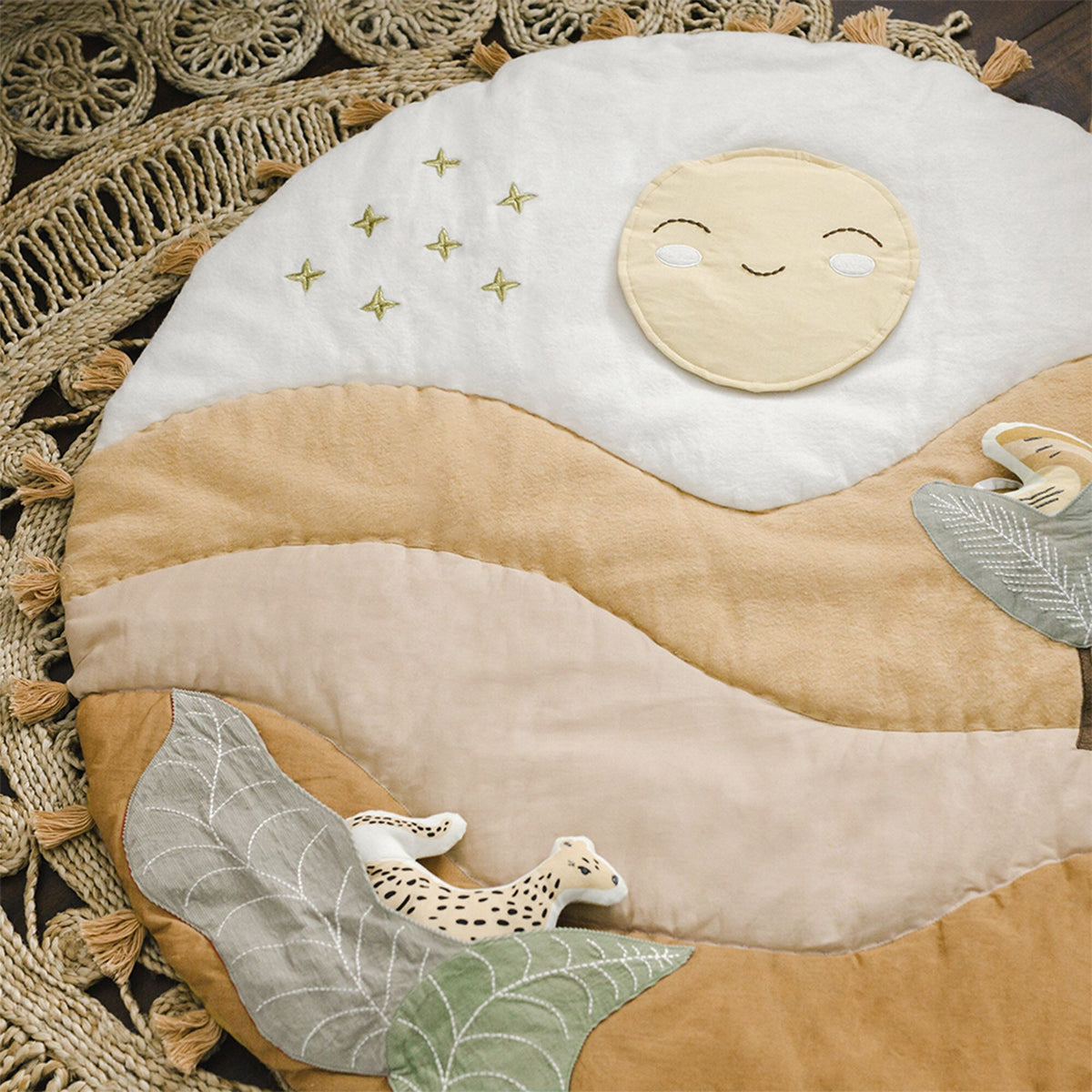 Children's play mat with a moon, stars, and animals on a textured surface