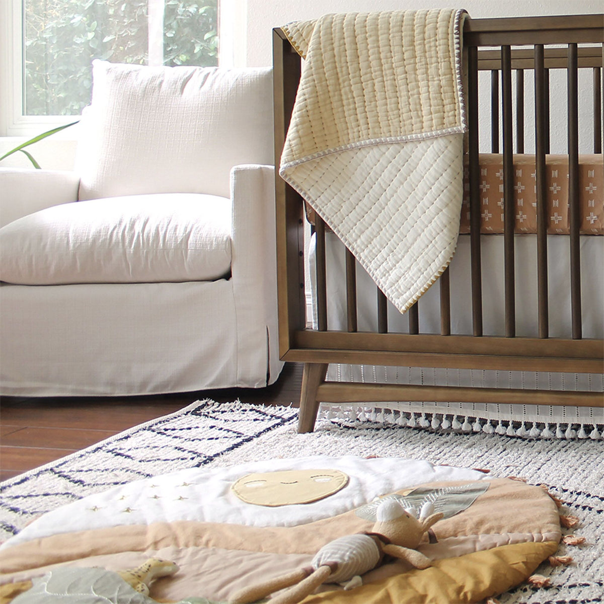 Round mat with leaf patterns, tassels, and a toy on a beige background