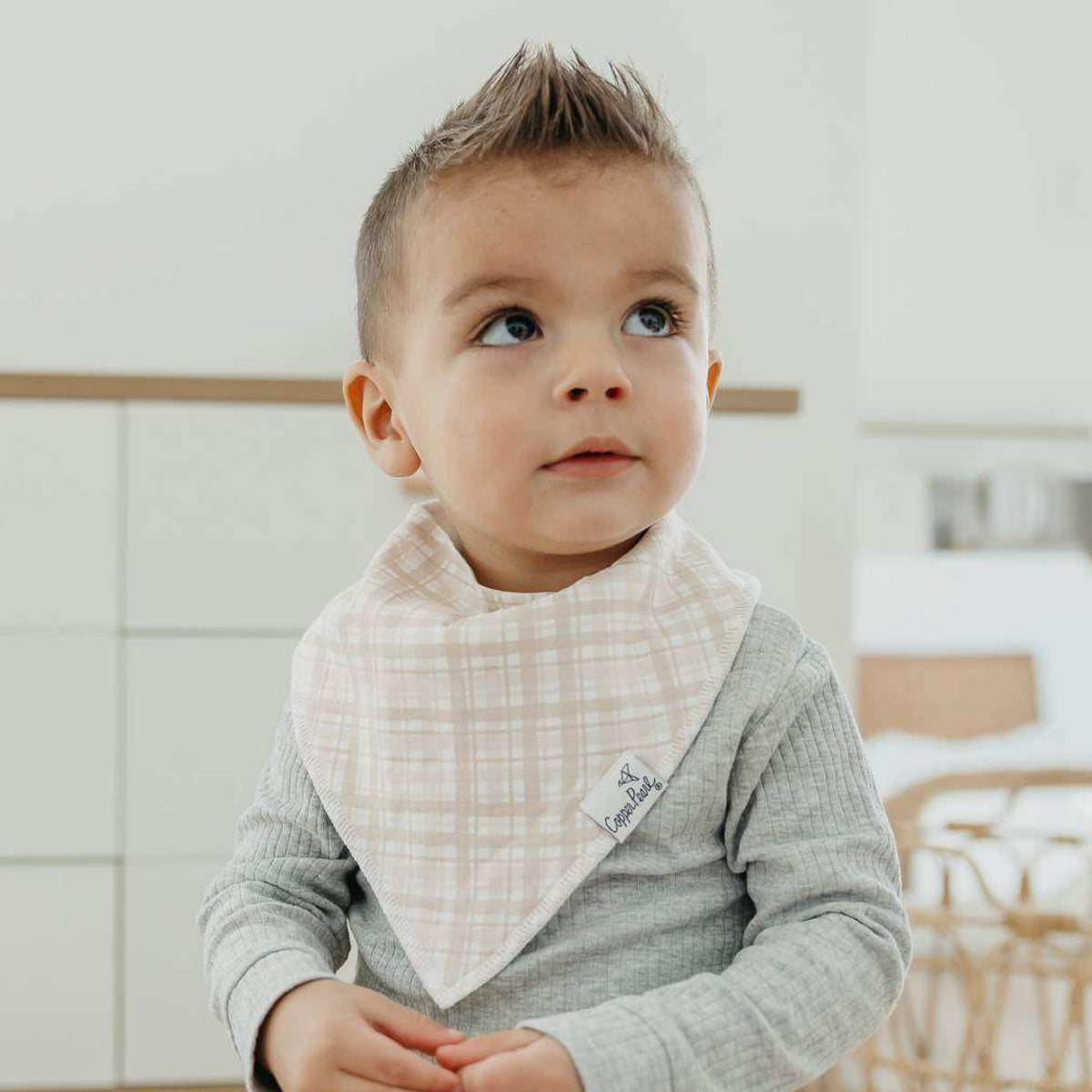 Child wearing a checkered bib indoors