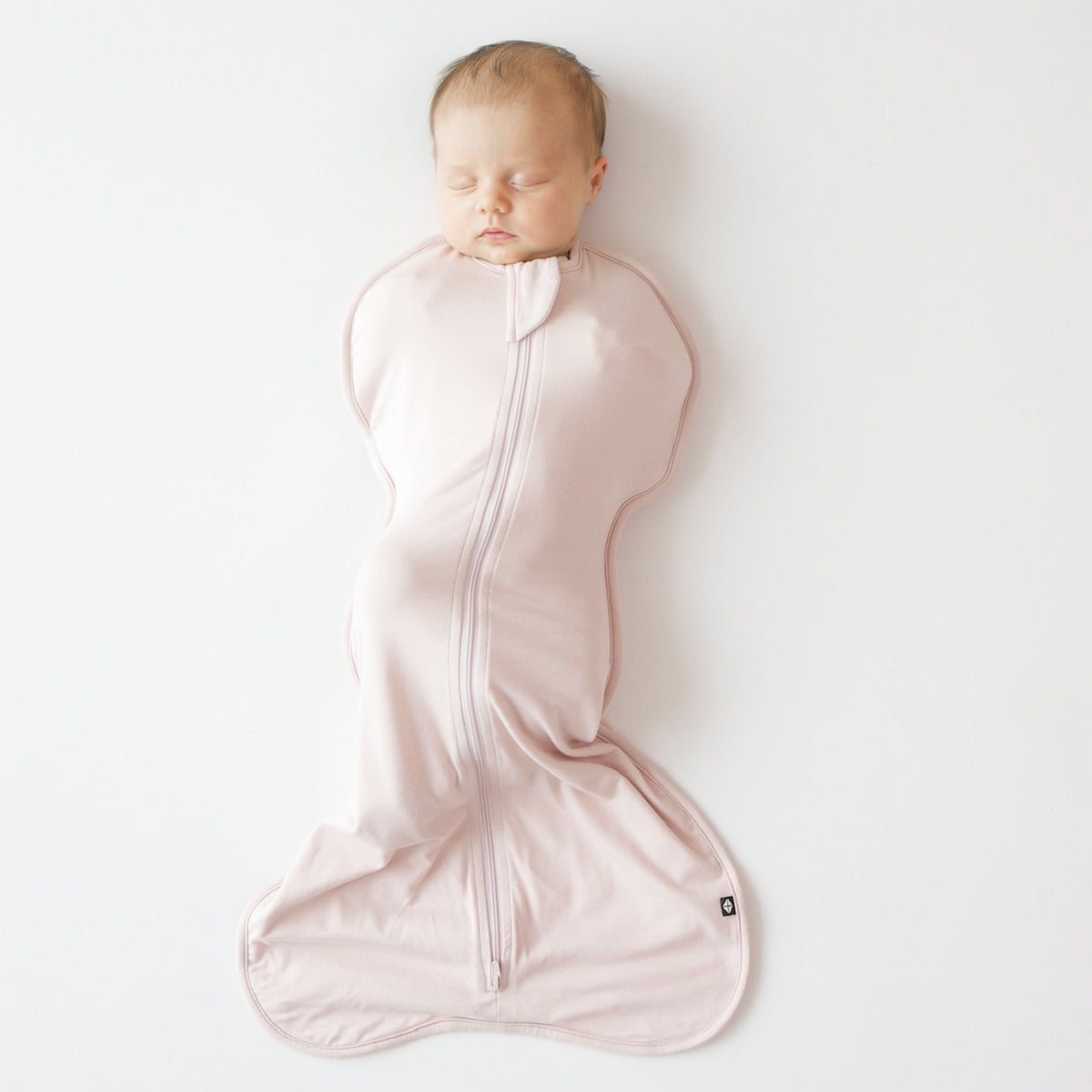 Newborn baby swaddled in a pink blanket on a white background