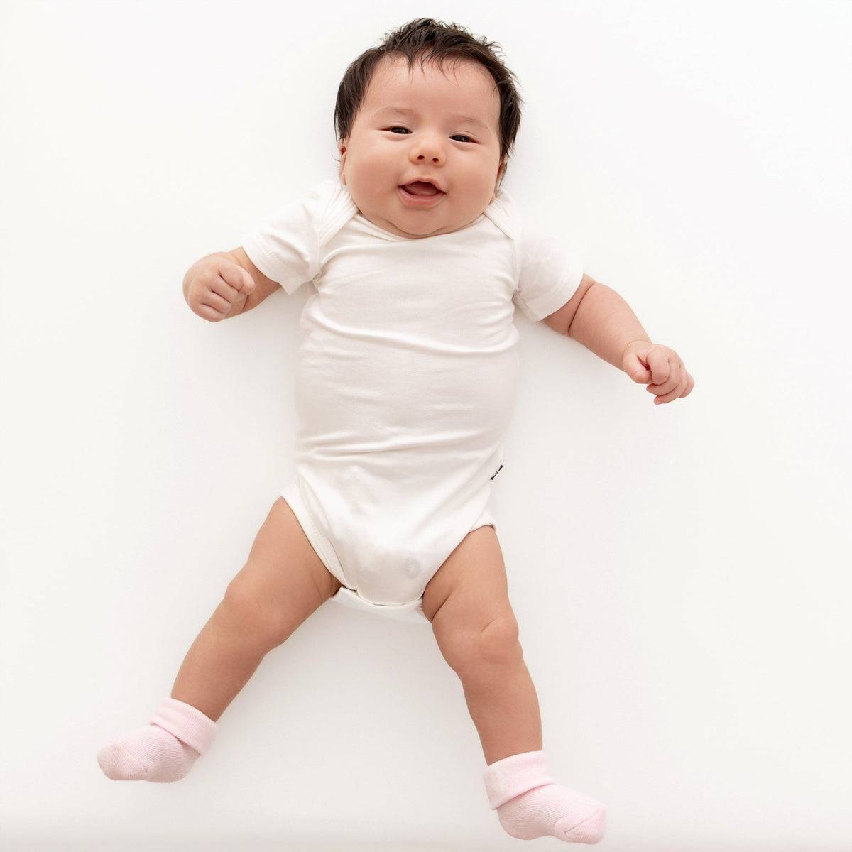 Baby in a white onesie on a white background