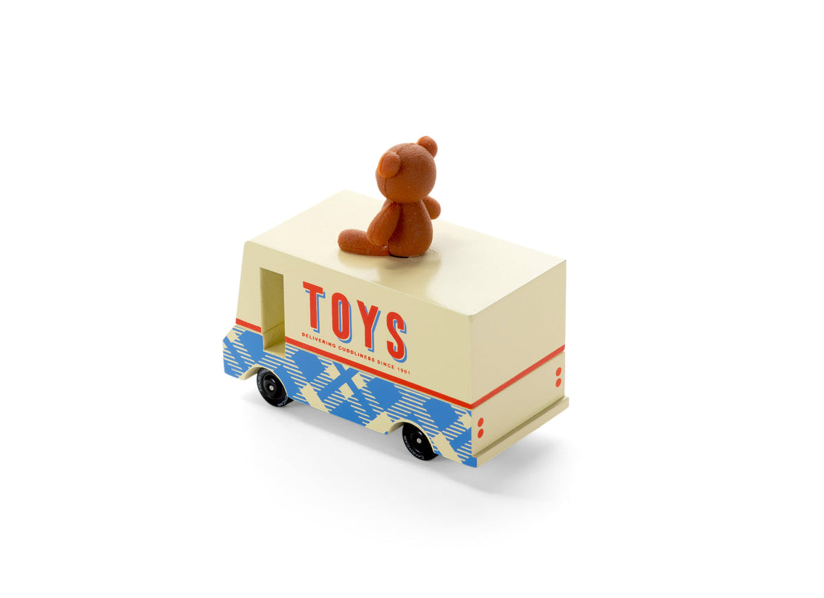 Toy truck with a teddy bear on top against a white background