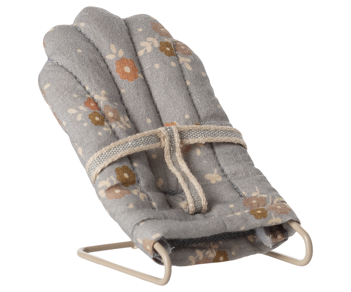 Folded fabric baby bouncer with floral pattern on a white background