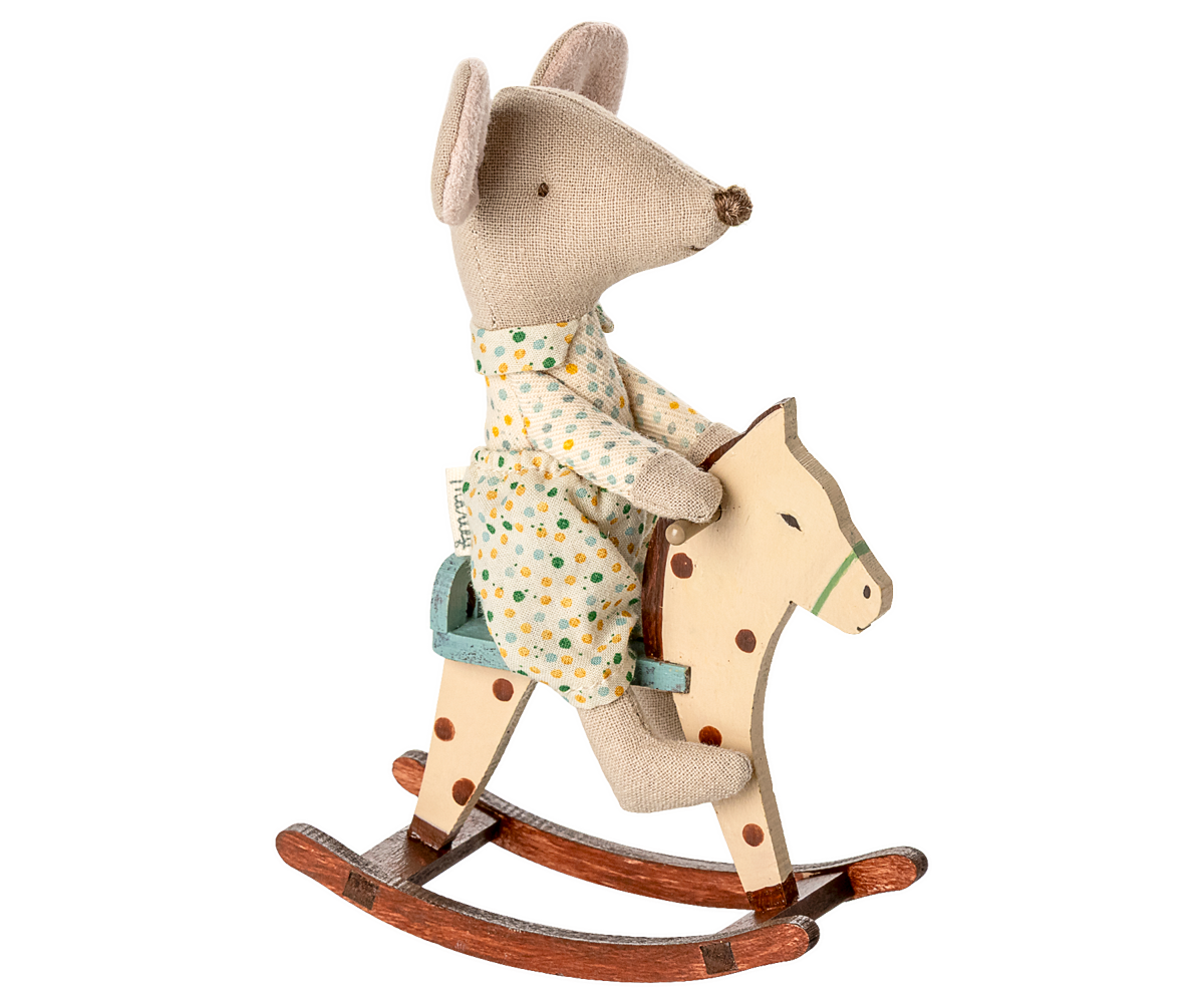 Stuffed mouse toy in pajamas riding a wooden rocking horse on a white background