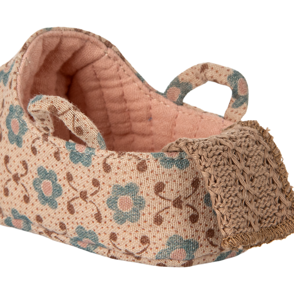 Floral-patterned fabric basket with a textured edge on a white background