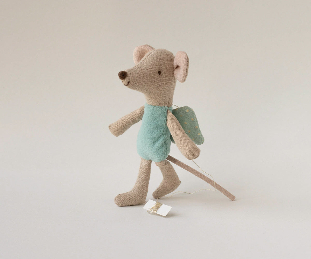 Stuffed toy mouse with a backpack on a plain background