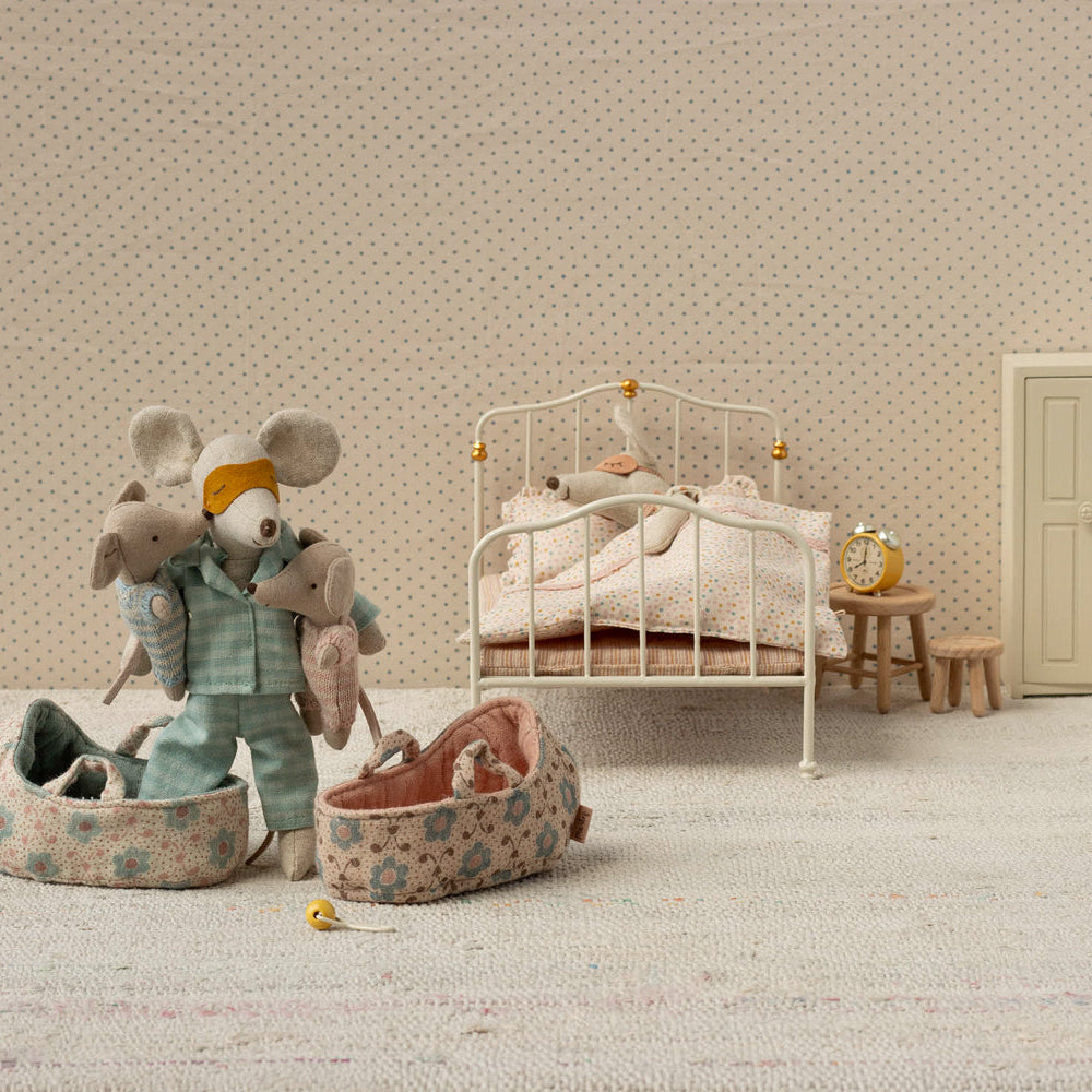Miniature bedroom scene with toys and furniture on a neutral background