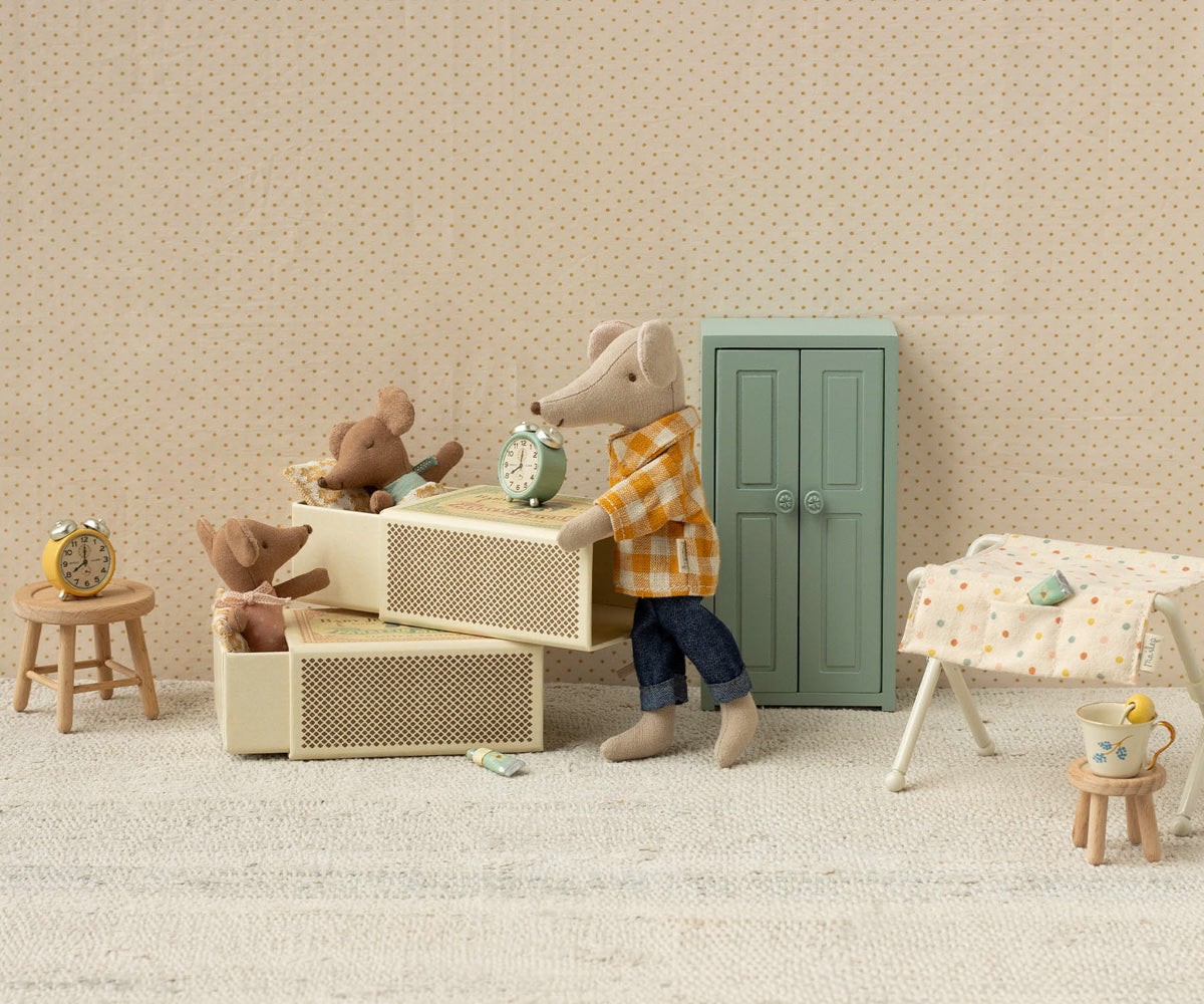Miniature scene with toy animals in a room setting on a beige textured background