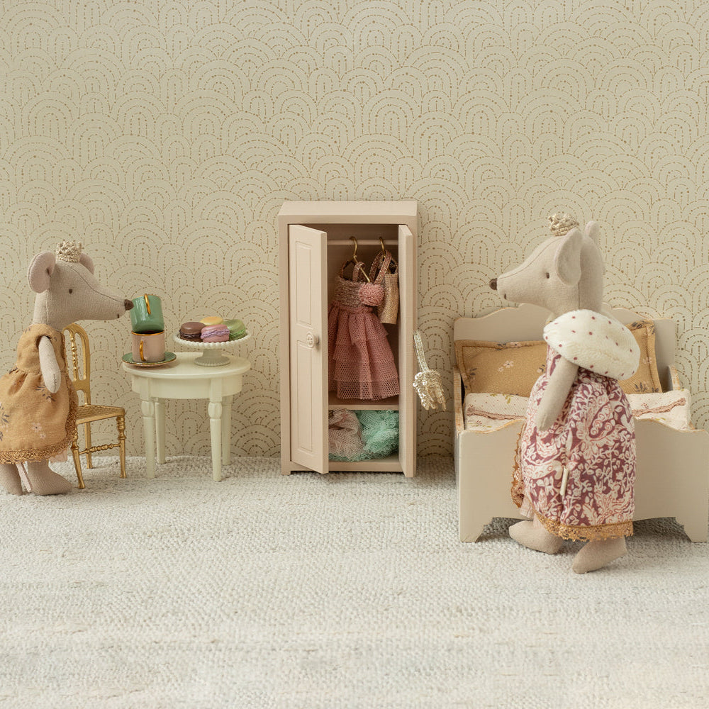 Miniature scene with toy mice in a room setting, including a wardrobe and furniture.