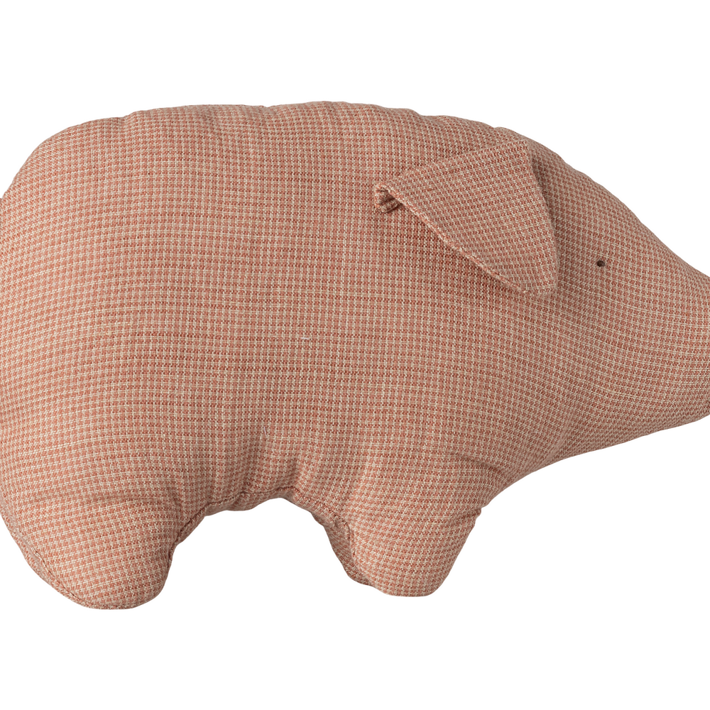 A soft, dusty pink linen stuffed pig toy with a simple stitched face and a small curled tail, viewed from the side against a transparent background.