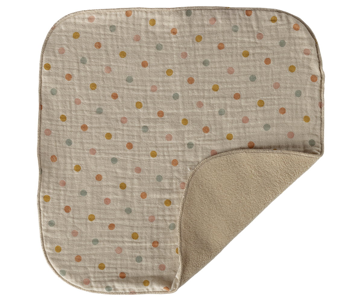 Baby blanket with polka dot pattern on beige background
