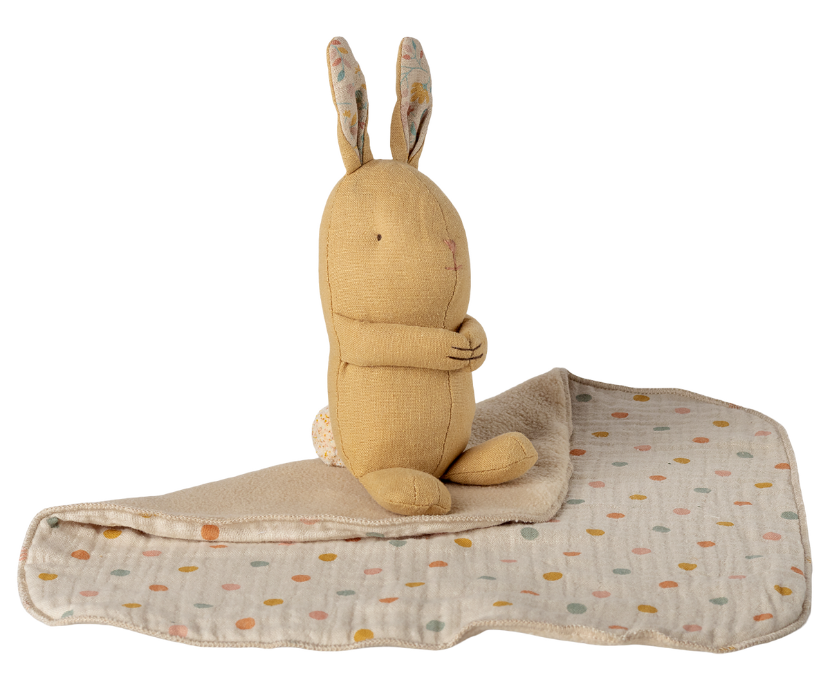 Plush rabbit toy with a patterned blanket on a white background