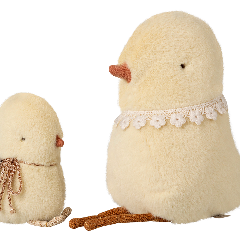 Two fluffy, cream-colored chicks with lace details on a white background