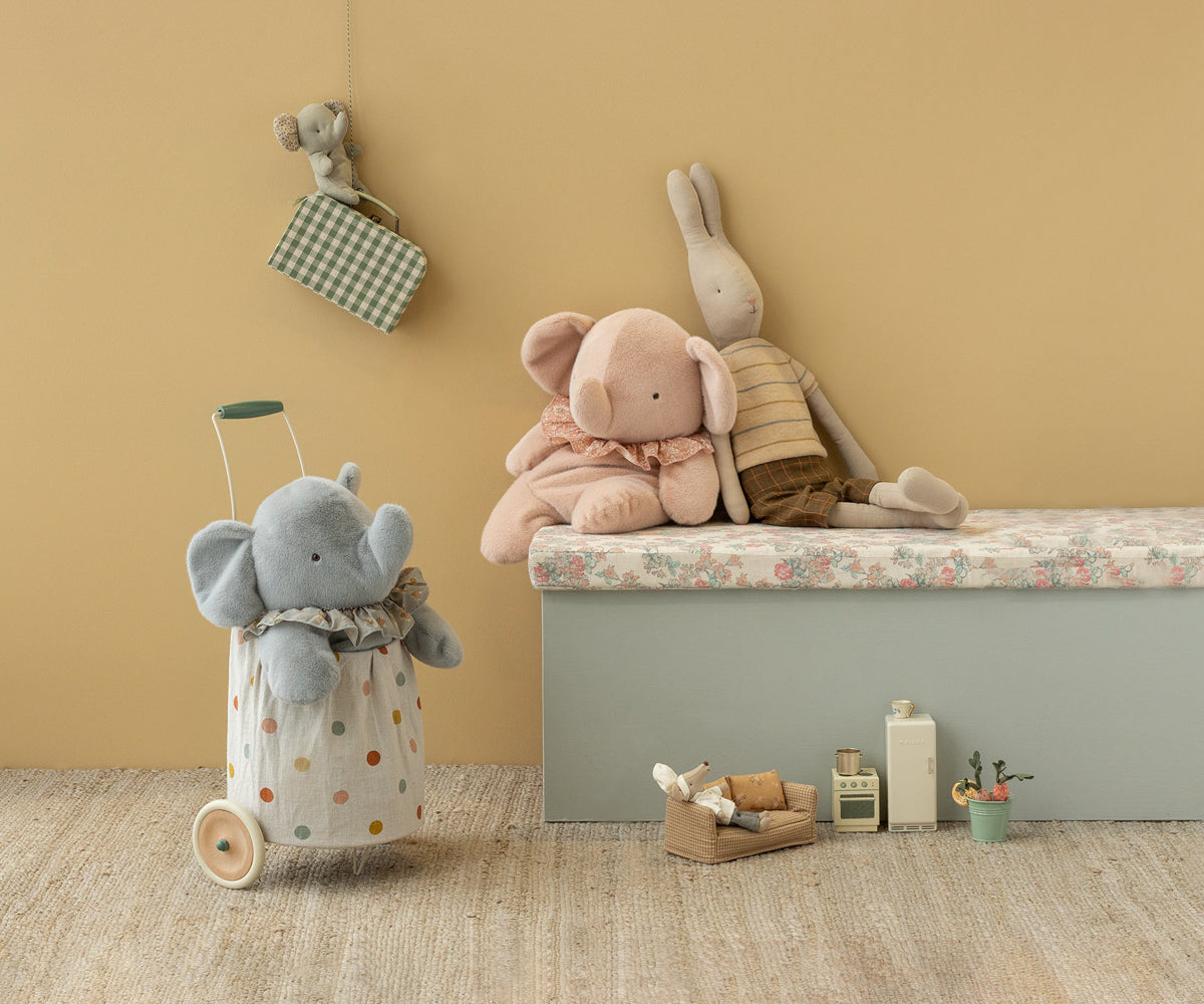 Children's room with plush toys and storage box against a beige wall.