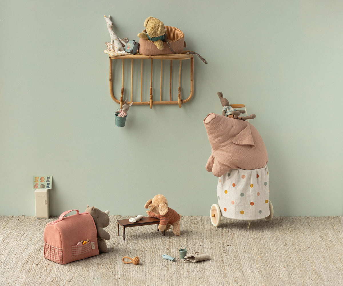 Children's room with toys and a shelf against a light green wall.