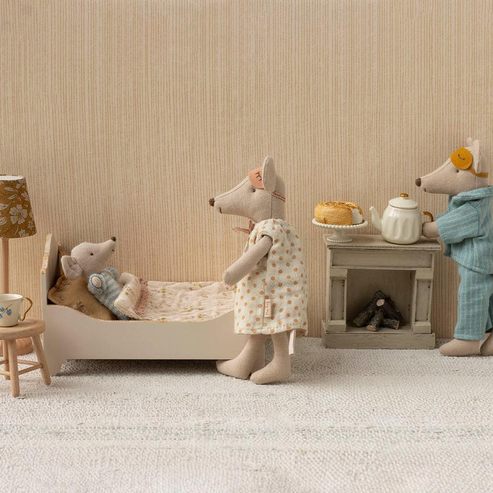 Maileg Mum mouse standing beside a miniature bathtub where Dad mouse sits inside, set in a dollhouse bathroom with a small toilet, sink, and tiled floor.