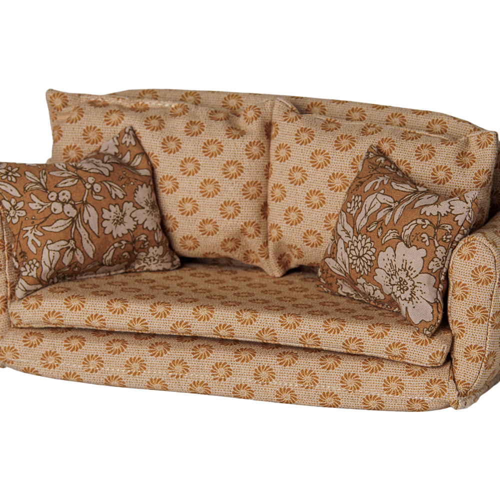 A miniature ocher fabric sofa for a toy mouse house, featuring a retro floral pattern in shades of brown and cream, complete with matching back cushions and side pillows against a transparent background.