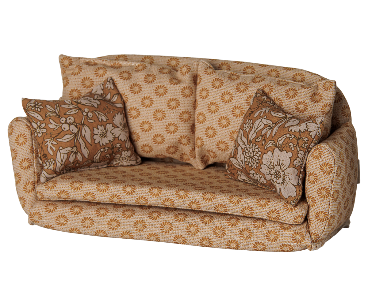 A miniature ocher fabric sofa for a toy mouse house, featuring a retro floral pattern in shades of brown and cream, complete with matching back cushions and side pillows against a transparent background.