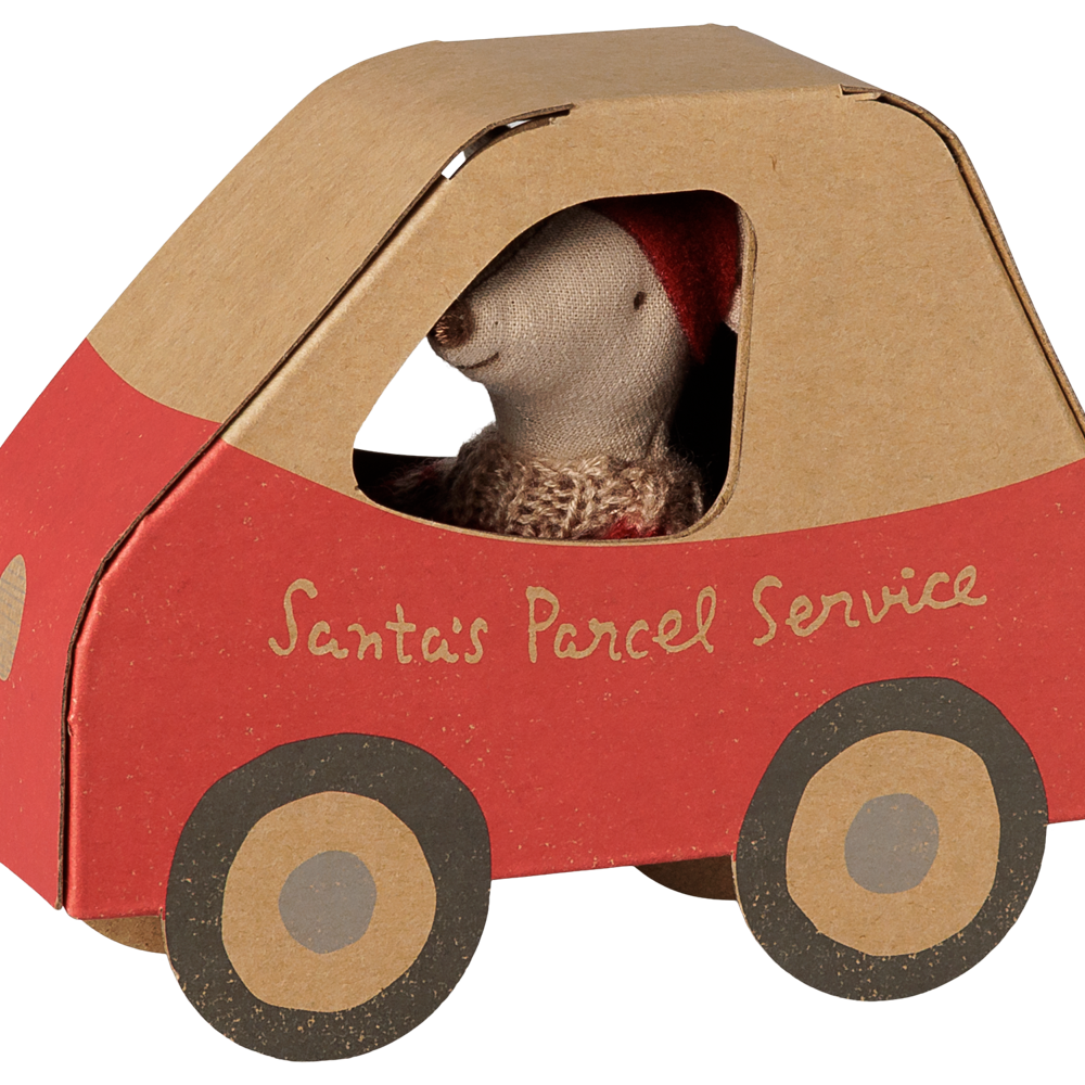A Maileg Christmas Little Sister mouse wearing a festive red and white patterned knit sweater and a red pixy hat, peeking out from the window of a miniature cardboard car-shaped box labeled "Santa's Parcel Service" with red detailing and illustrated wheels.
