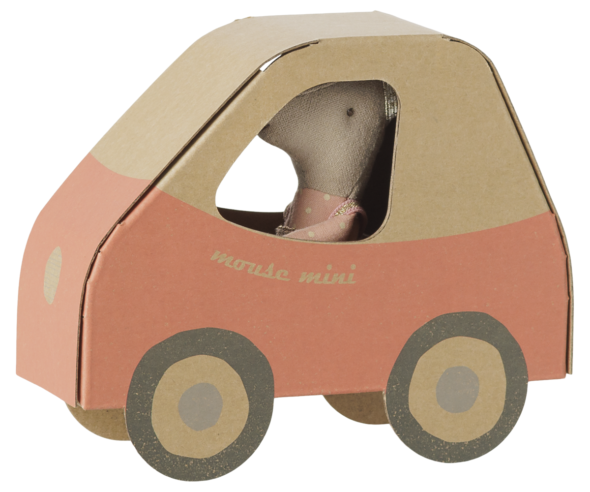 A small toy mouse doll wearing a pink dress, seated inside a cardboard car-shaped playhouse with a peach and tan design, on a plain white background.