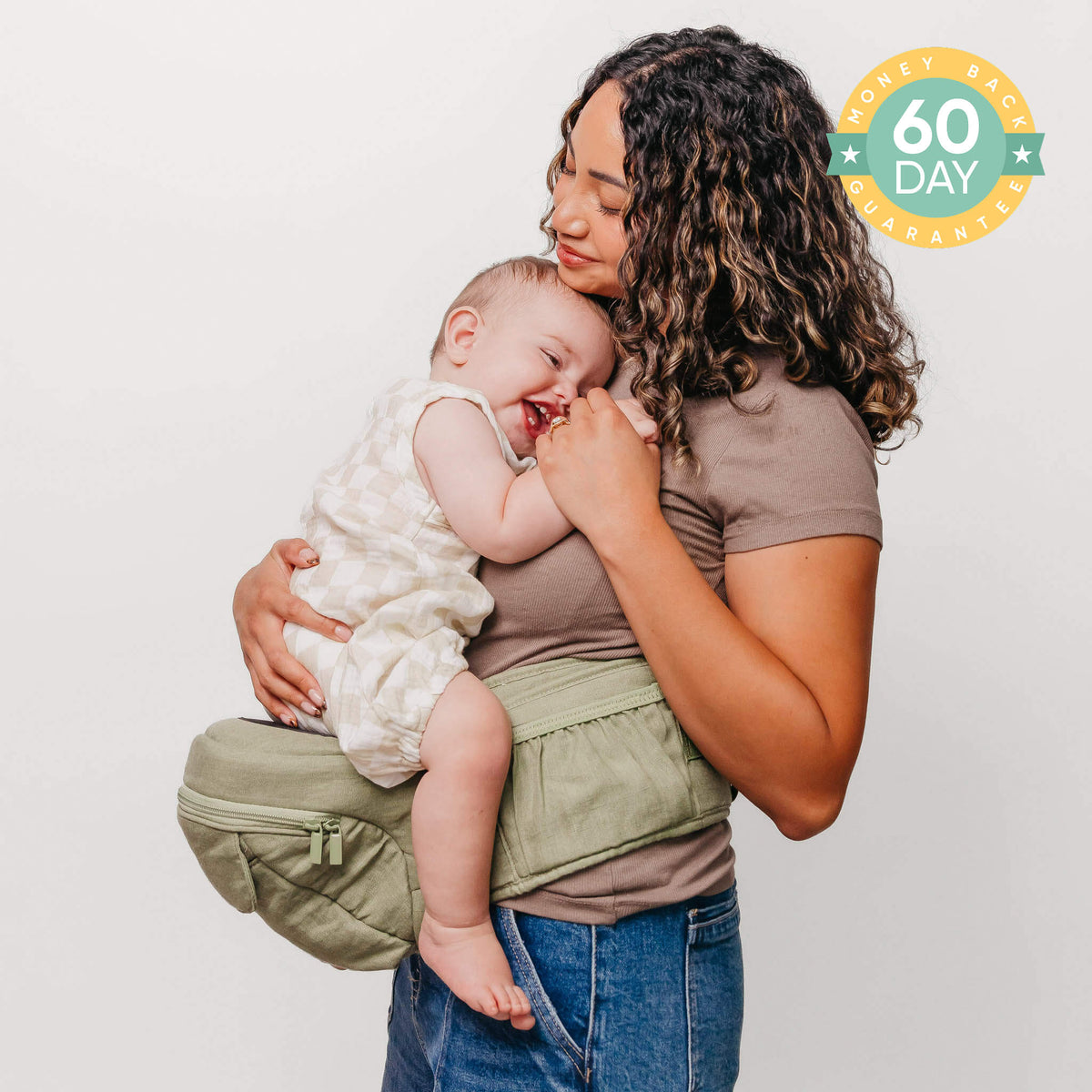 Woman holding a baby in a green baby carrier with a '60 Day' badge in the corner.