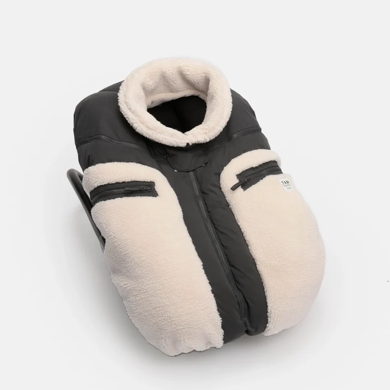 A baby footmuff in black and cream fleece, shown on a clean white background.