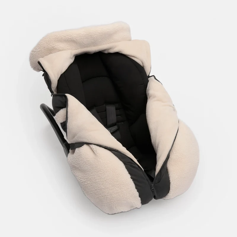 A beige fleece-lined car seat cover with black trim and a black interior padding, shown from an overhead angle on a light gray background.