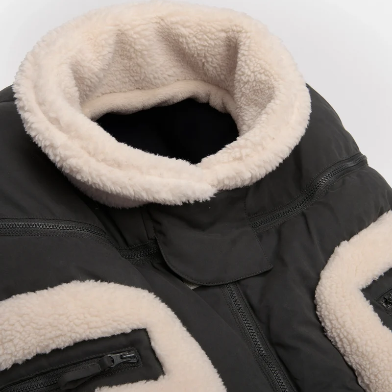 Benji Applique Car Seat Cocoon by 7AM Enfant featuring a closeup of the dark grey weatherproof outer shell, plush ivory sherpa fleece trim around the collar and zippered side pocket, and front zipper detail.