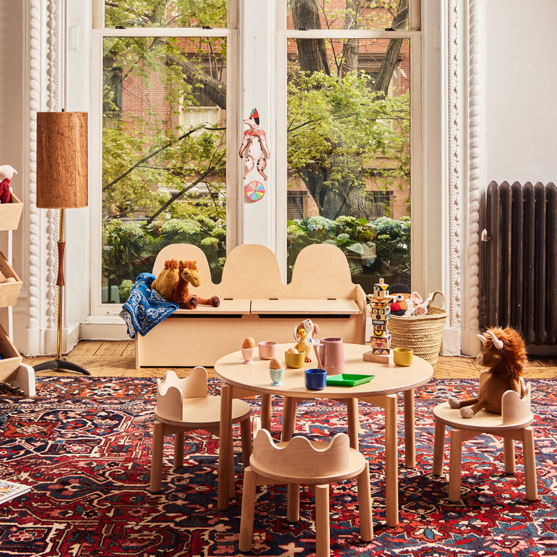 Children's play area with wooden furniture, toys, and a large window.