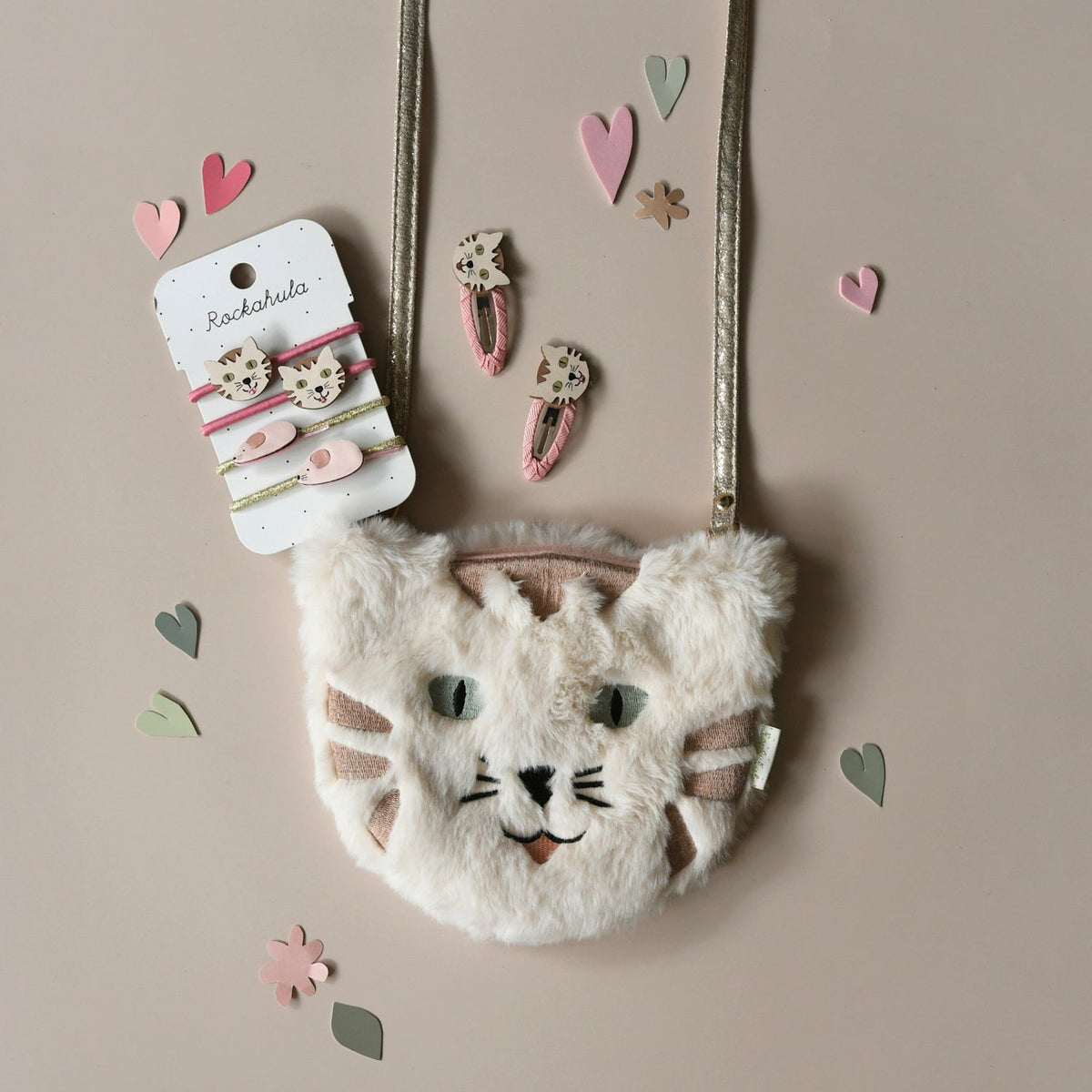 Fluffy cat-shaped handbag with hair accessories on a beige background