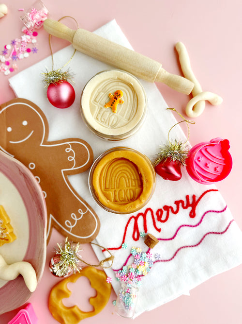 Cookie cutters with Christmas-themed decorations on a pink background