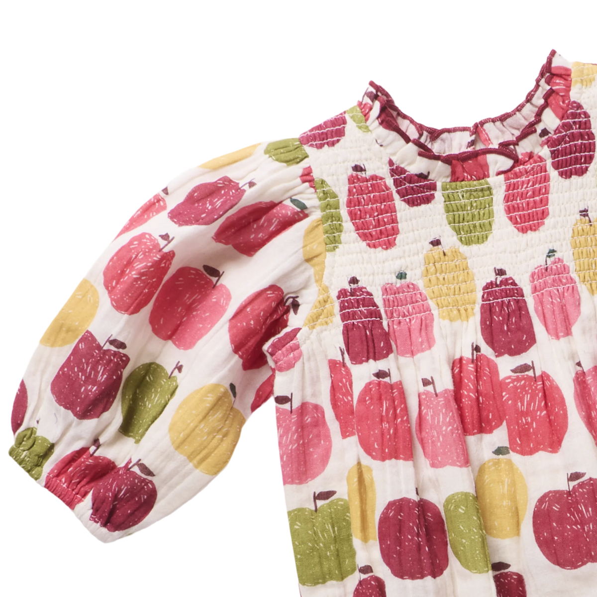 A baby smocked blouse with puff sleeves, featuring a colorful pattern of red, pink, yellow, and green apples on a white background.