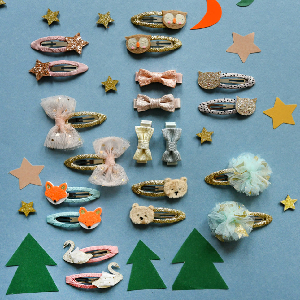 Collection of colorful hair accessories on a blue background with decorative items.