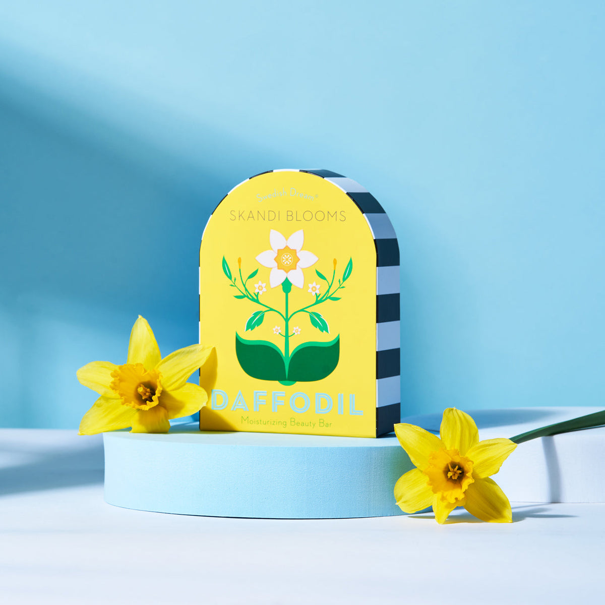 Skandi Blooms daffodil product packaging with two yellow flowers on a blue background
