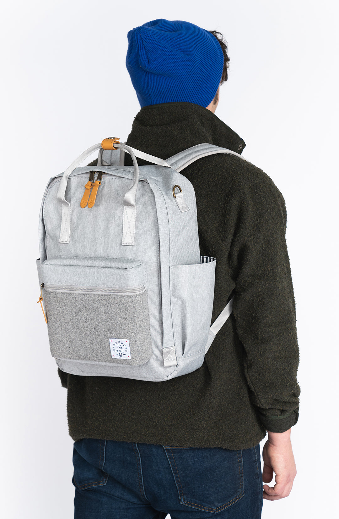 Person wearing a gray backpack with a visible brand logo on a white background