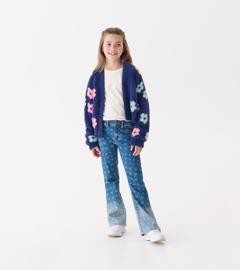 Person wearing a blue jacket and blue denim jeans with a subtle heart pattern.