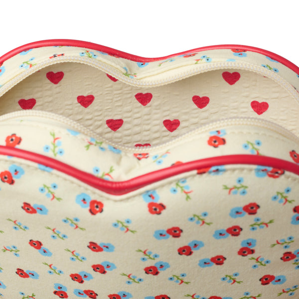Close-up of a heart-shaped bag or pouch with a cream background, red and blue floral print, and red trim, shown open against a white background.