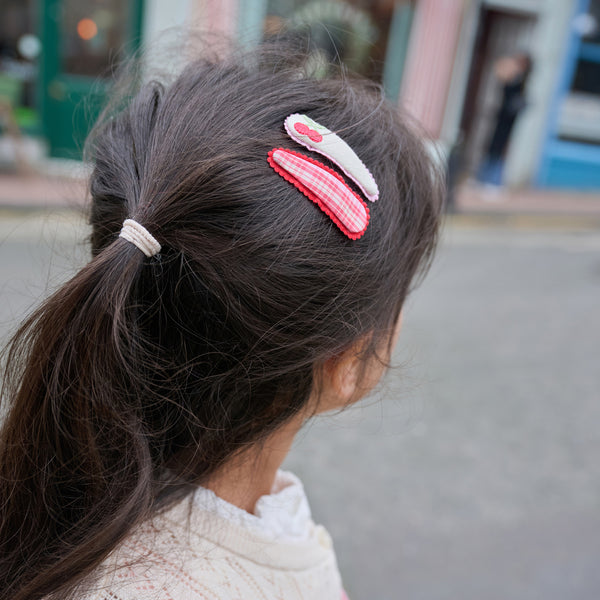Close-up of a person's hair with decorative hair clips in an urban setting