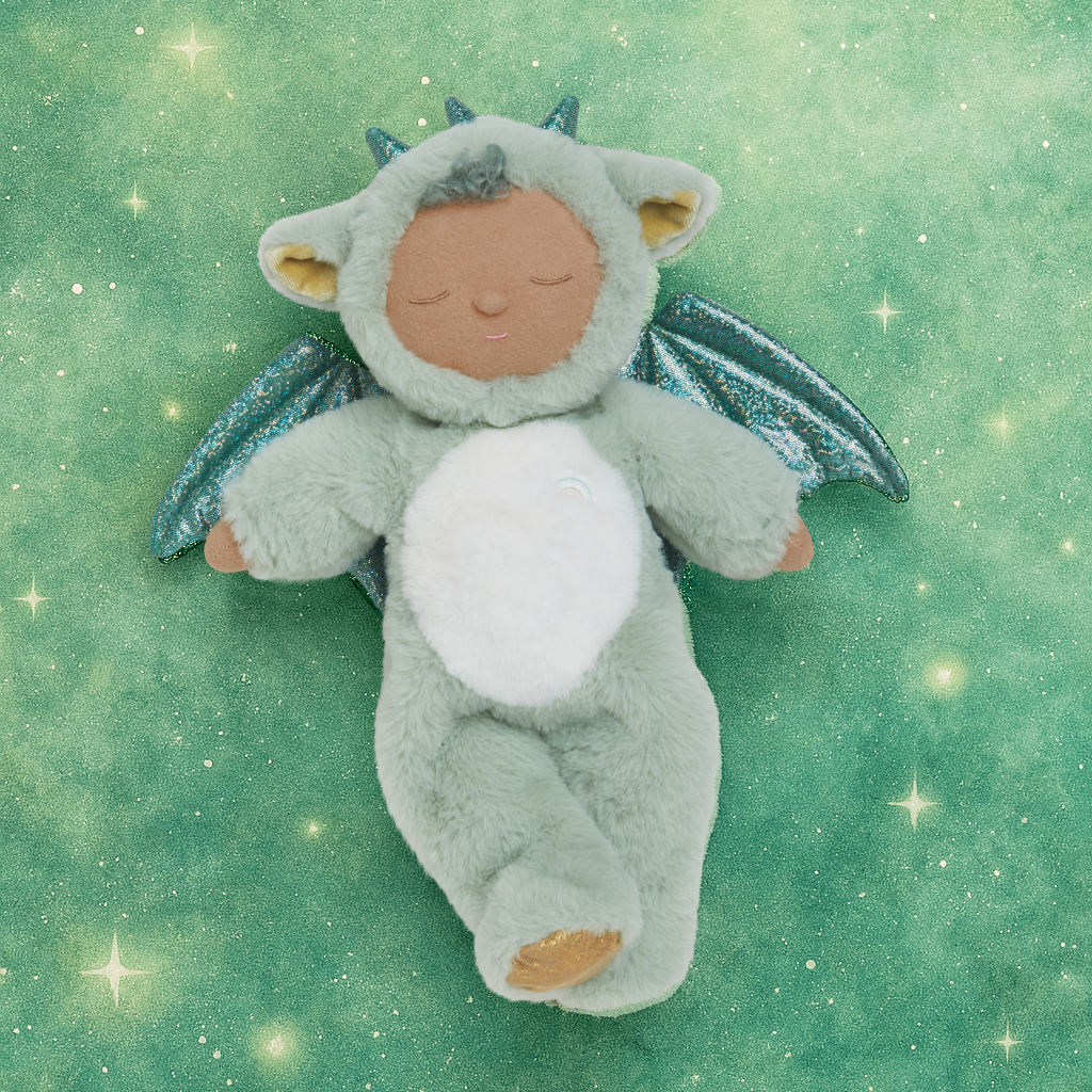 Plush toy dragon on a green background with star-like lights