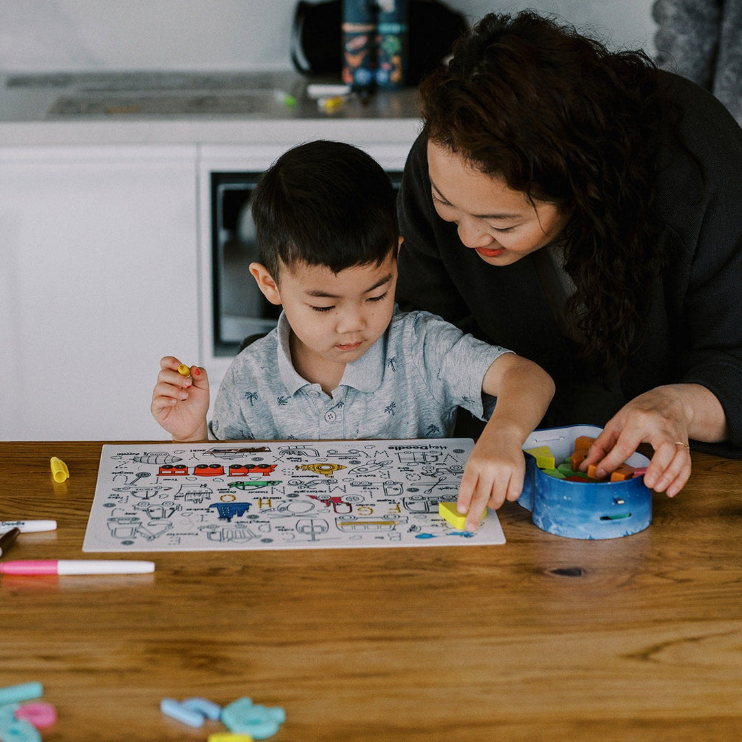 Woman and child at a table with coloring book and crayons